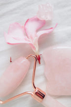 Rodillo Masajeador Facial de Jade con Guasha con un flor rosa