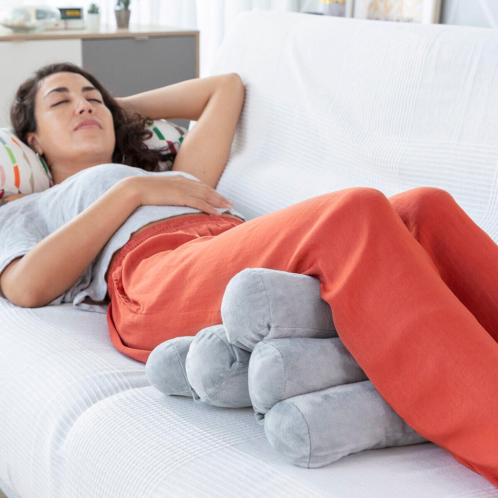 mujer con las piernas recostadas sobre la almohada modular multifunción Rollow
