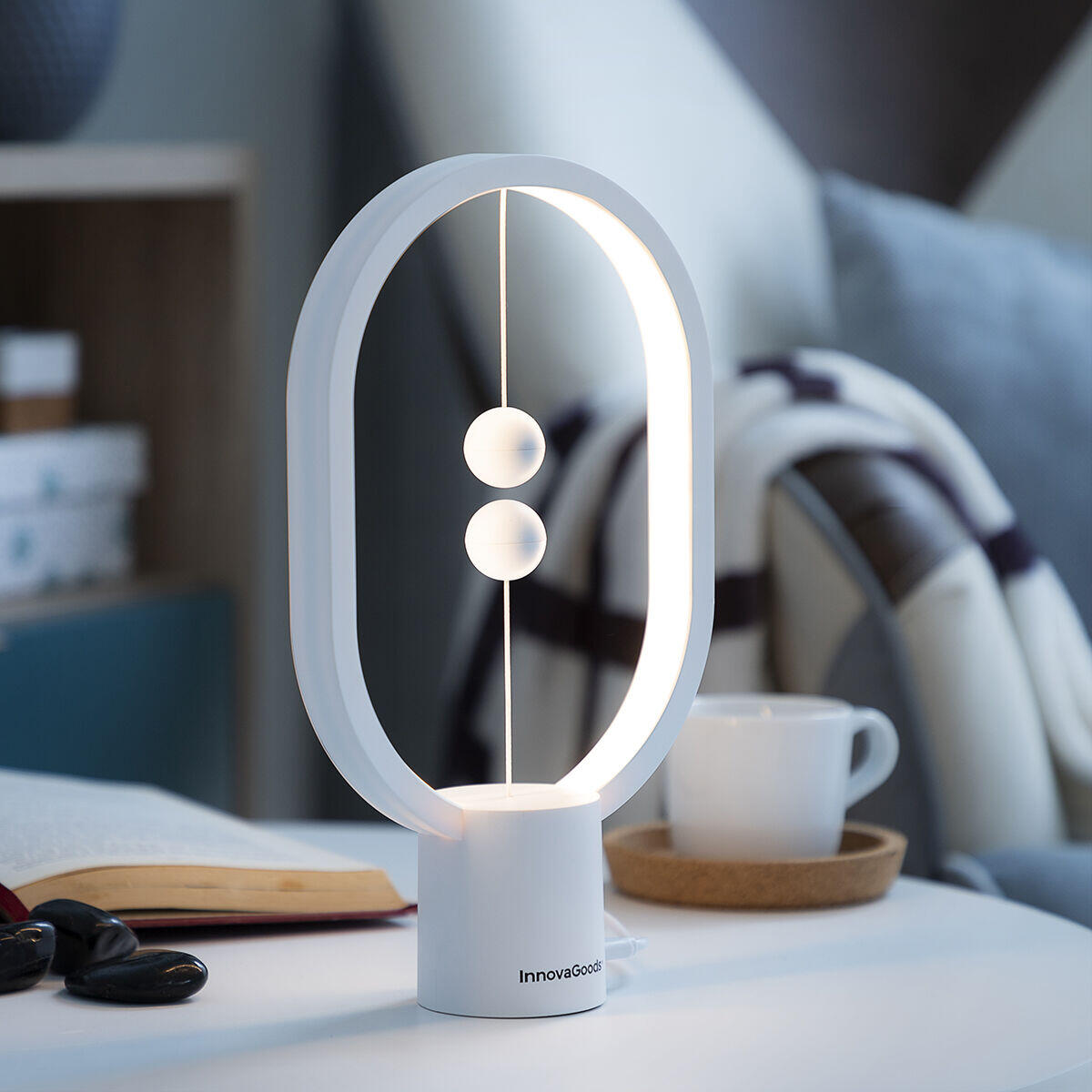 Lámpara de equilibrio con interruptor magnético encendida sobre mesa con taza