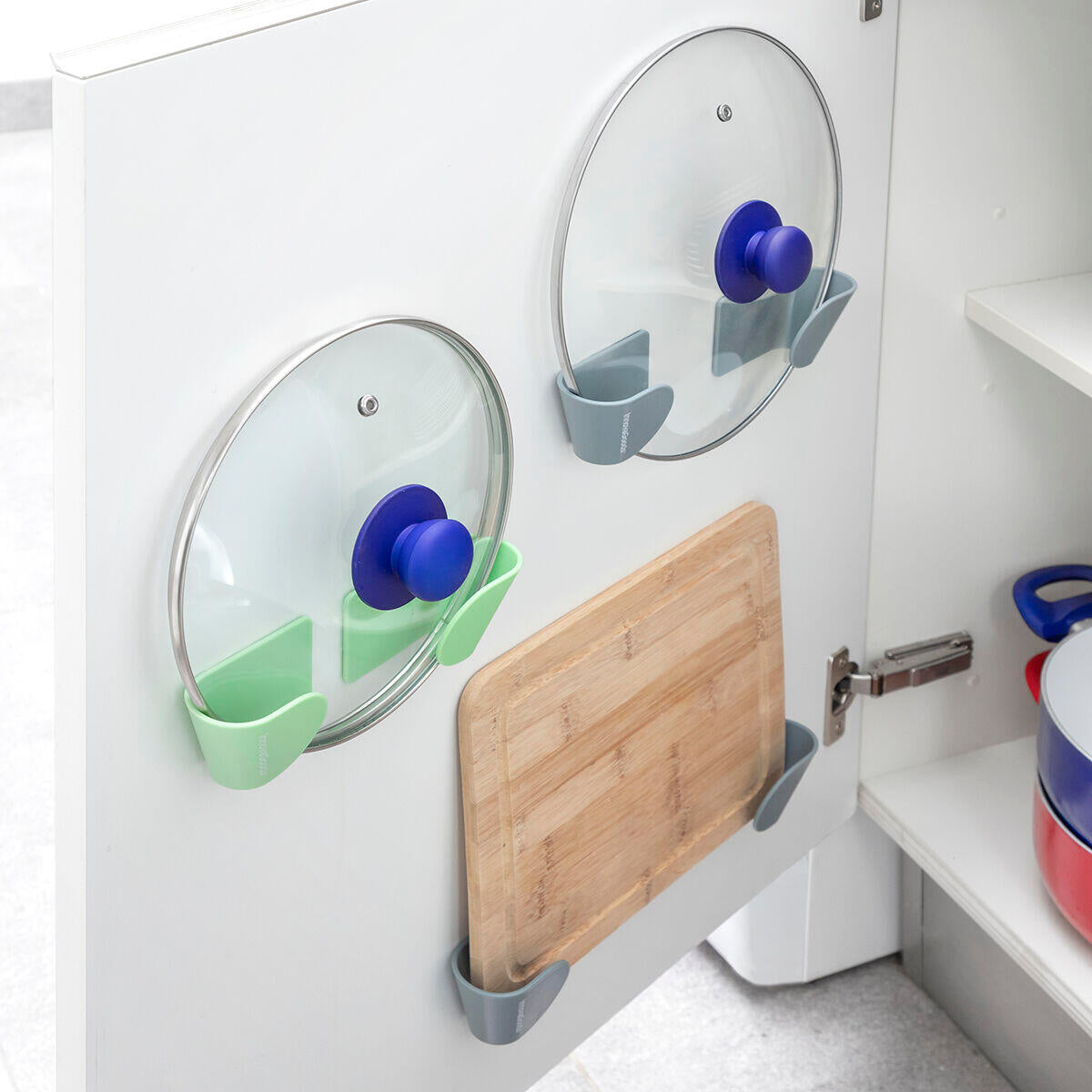 Soportes adhesivos para tapas de cocina instalados sobre repisa de cocina