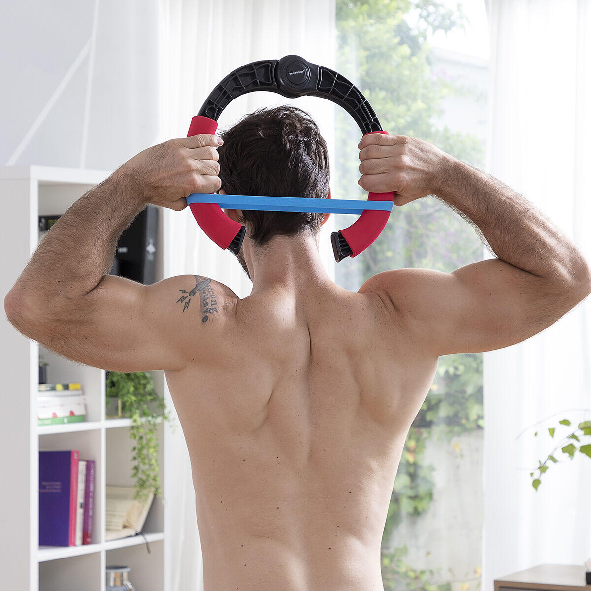 hombre entrenando con el Ejercitador de brazos vista de espaldas en casa