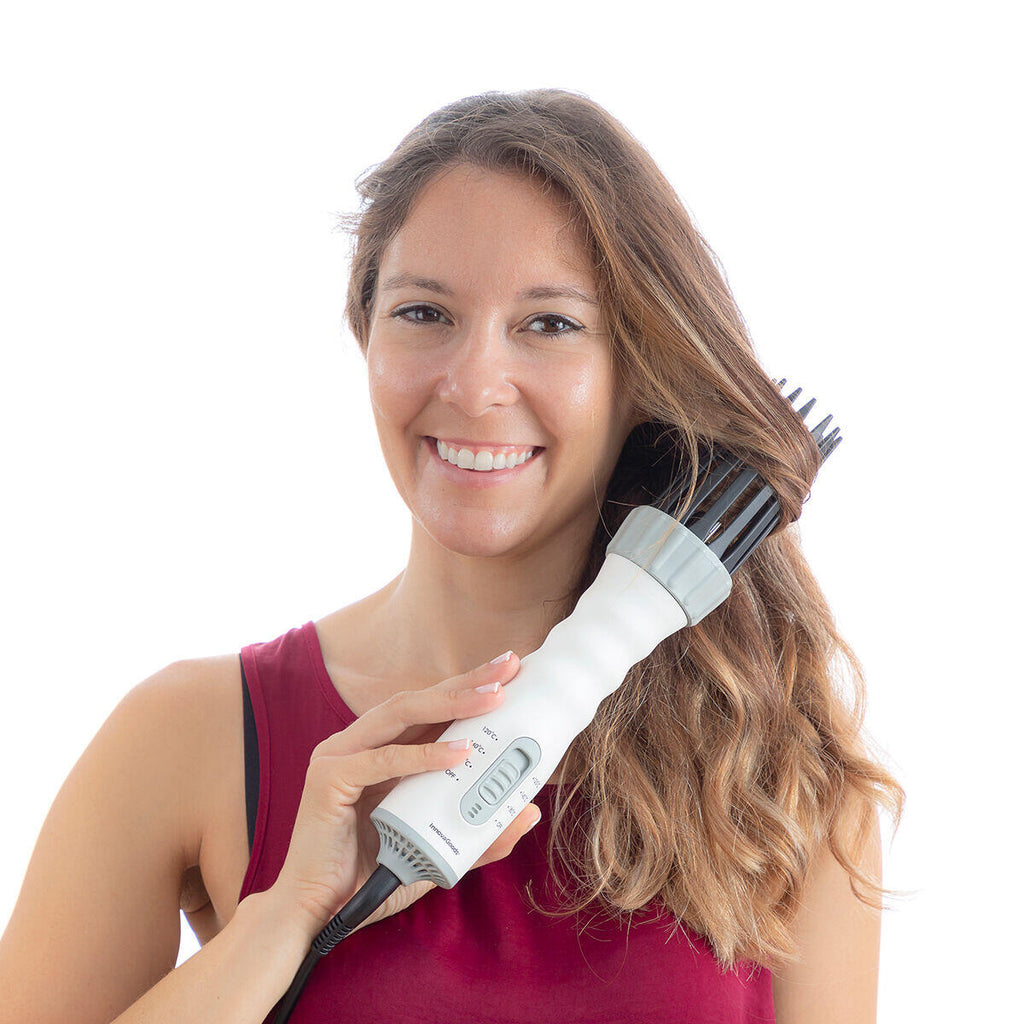 Mujer usando el cepillo secador secador y rizador Dryple 3 en 1