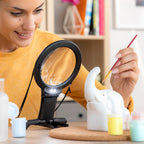 mujer usando Lupa manos libres para ver detalles sobre escultura elefante