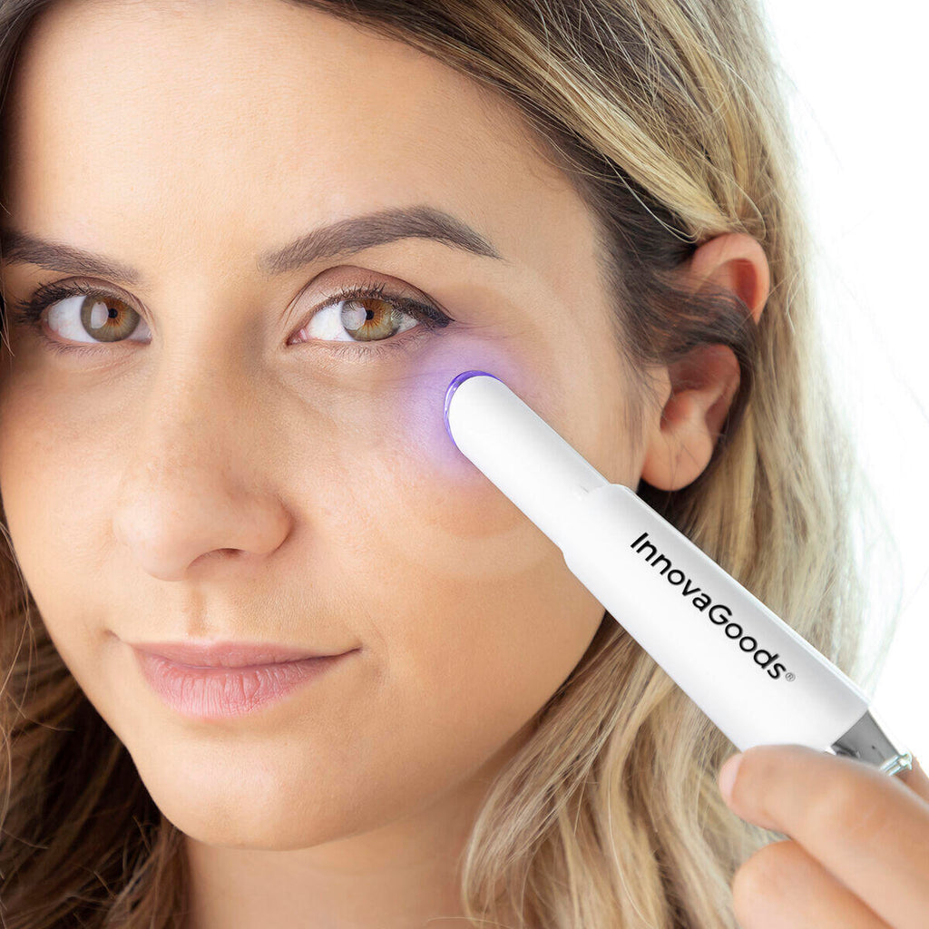 mujer colocando en ojeras el Masajeador antiedad para ojos con calor y vibración