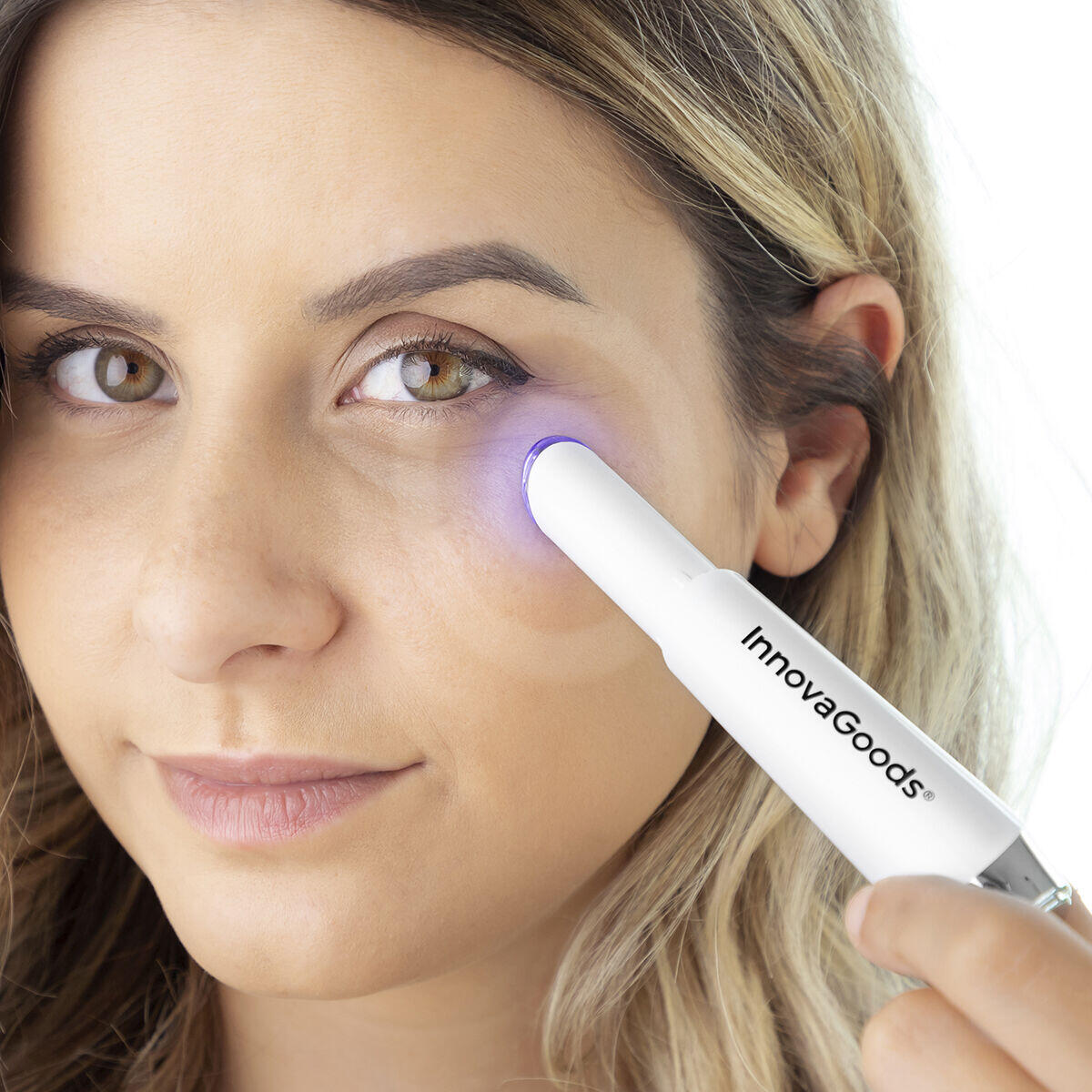 mujer colocando en ojeras el Masajeador antiedad para ojos con calor y vibración