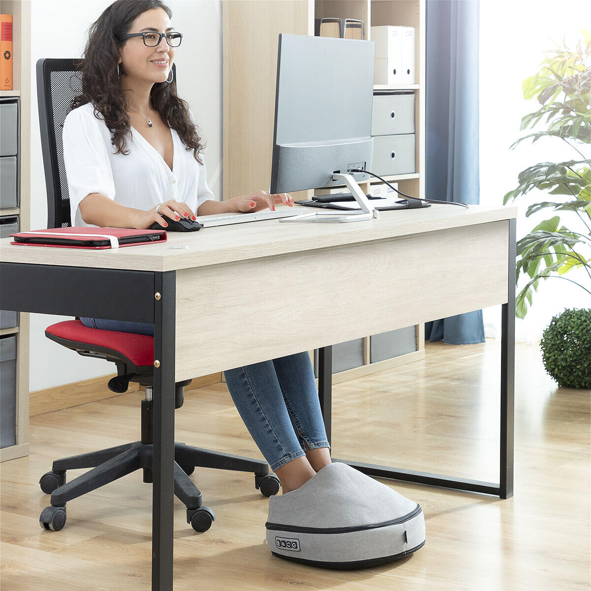 Mujer sentada en su escritorio trabajando mientras usa el Masajeador Shiatsu Térmico 2 en 1 Futsa 