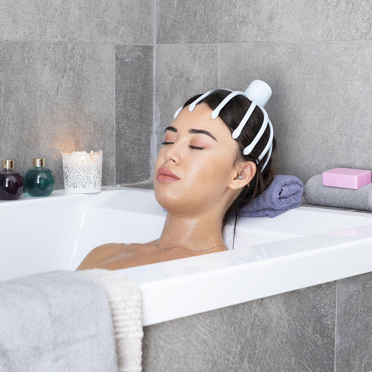 mujer relajada dentro de una bañera usando el Masajeador de cabeza recargable Helax 