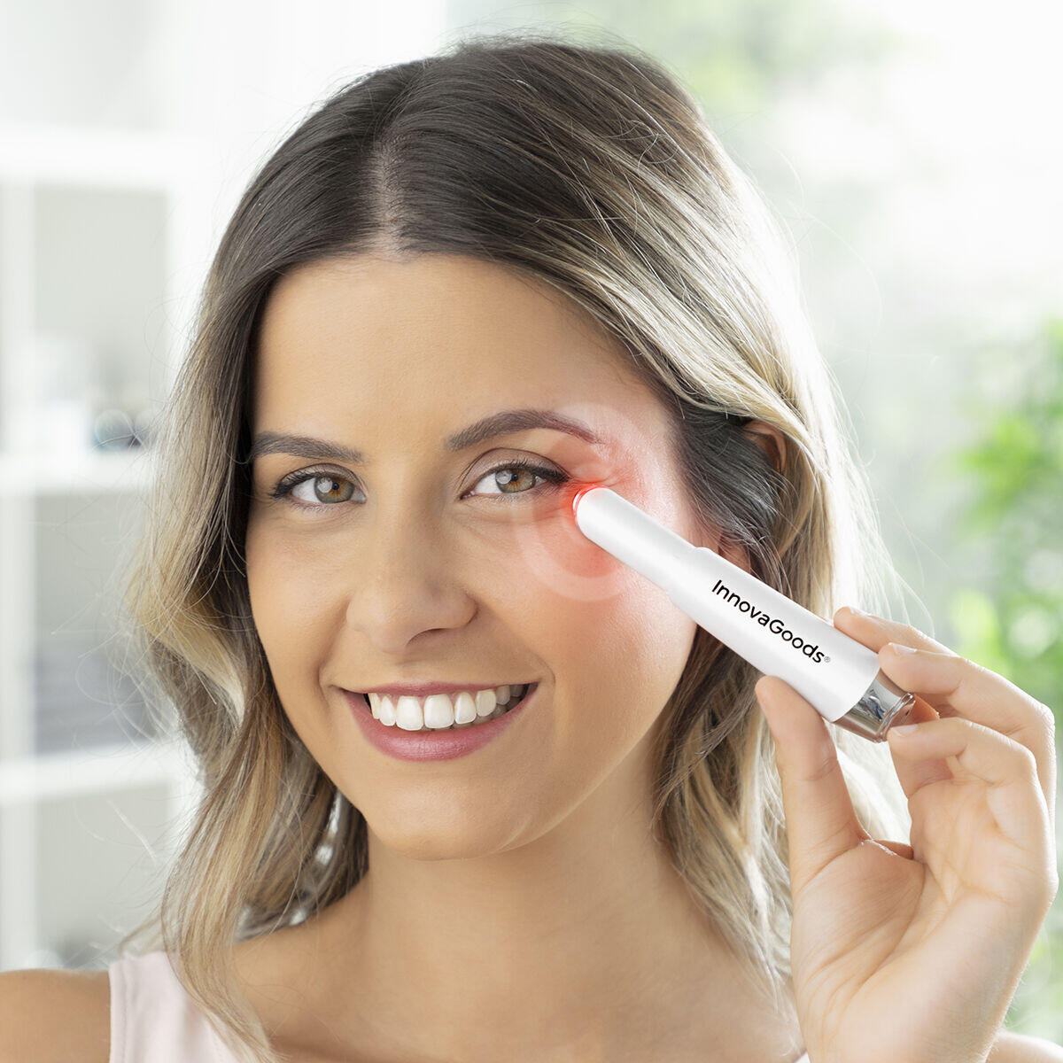 mujer usando el masajeador de ojos antiedad con fototerapia, termoterapia y vibración Therey 
