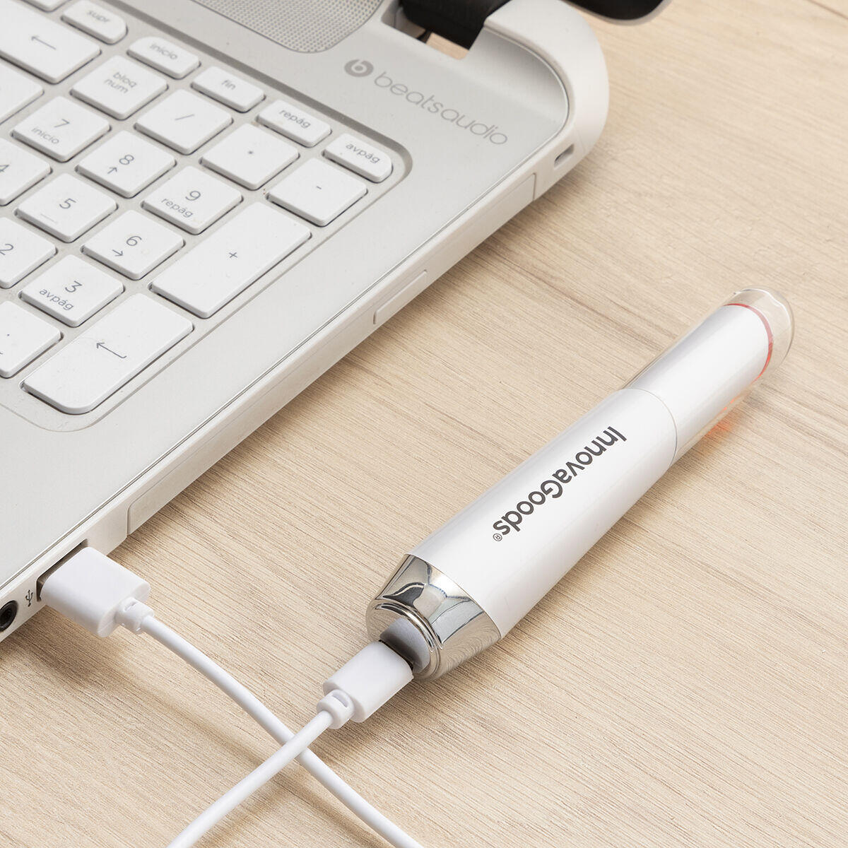 Masajeador antiedad para ojos con calor y vibración conectado con cable usb a una portátil