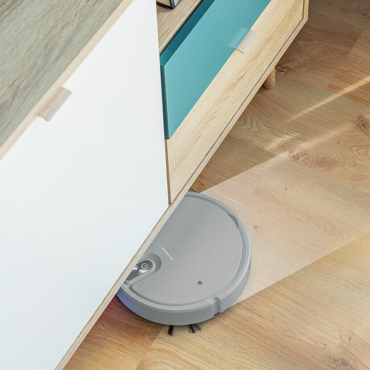 Robot Aspirador Recargable Multifunción 5 en 1 Varob limpiando debajo de un mueble