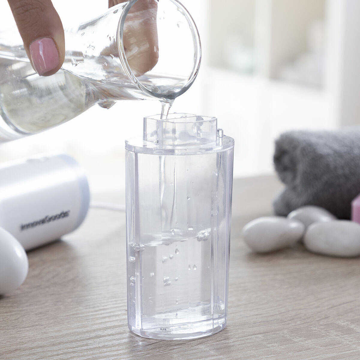 Persona llenando con el líquido el contenedor del Hidrolimpiador Facial de Impurezas Recargable Hyser