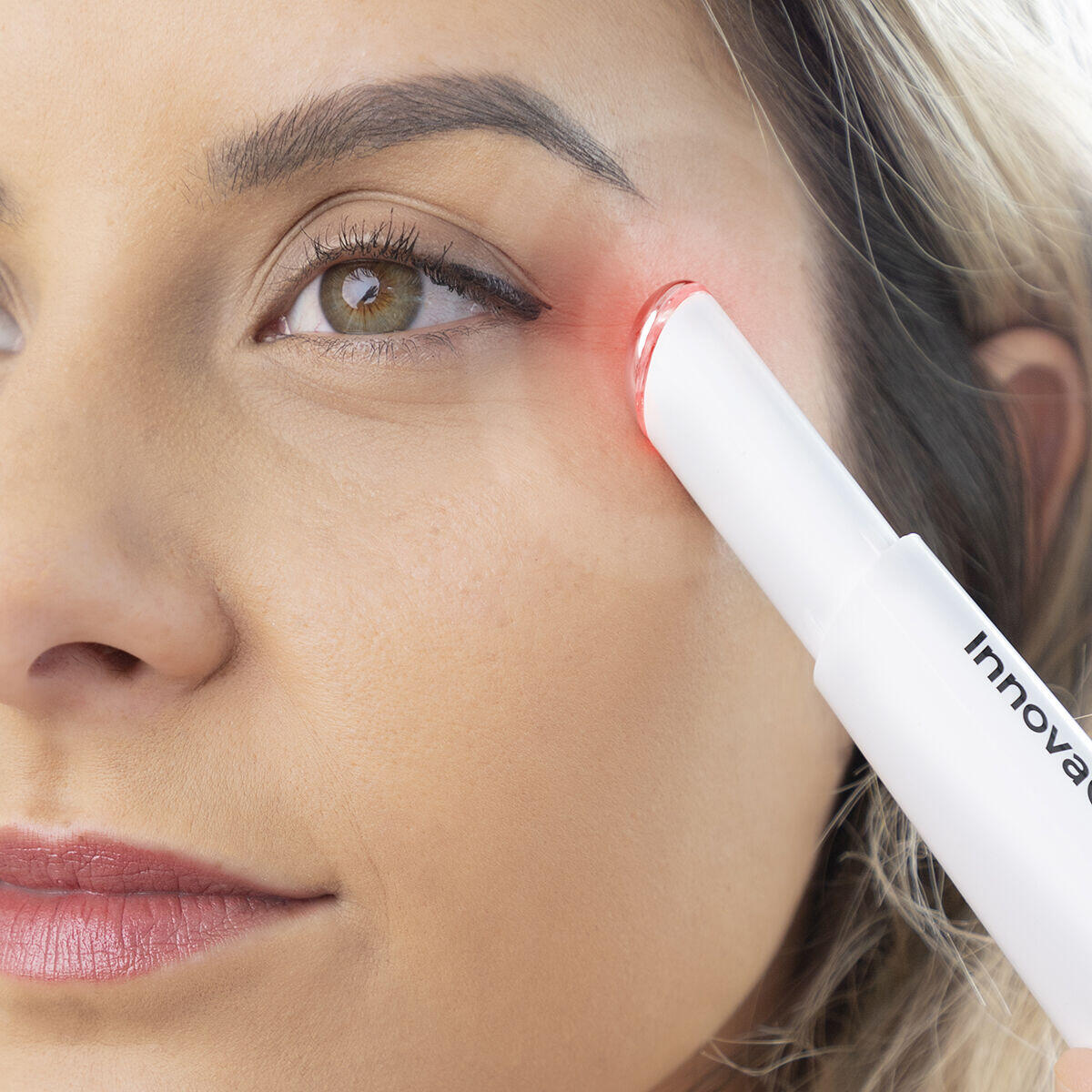 mujer usando el masajeador antiedad para ojos acción calor

