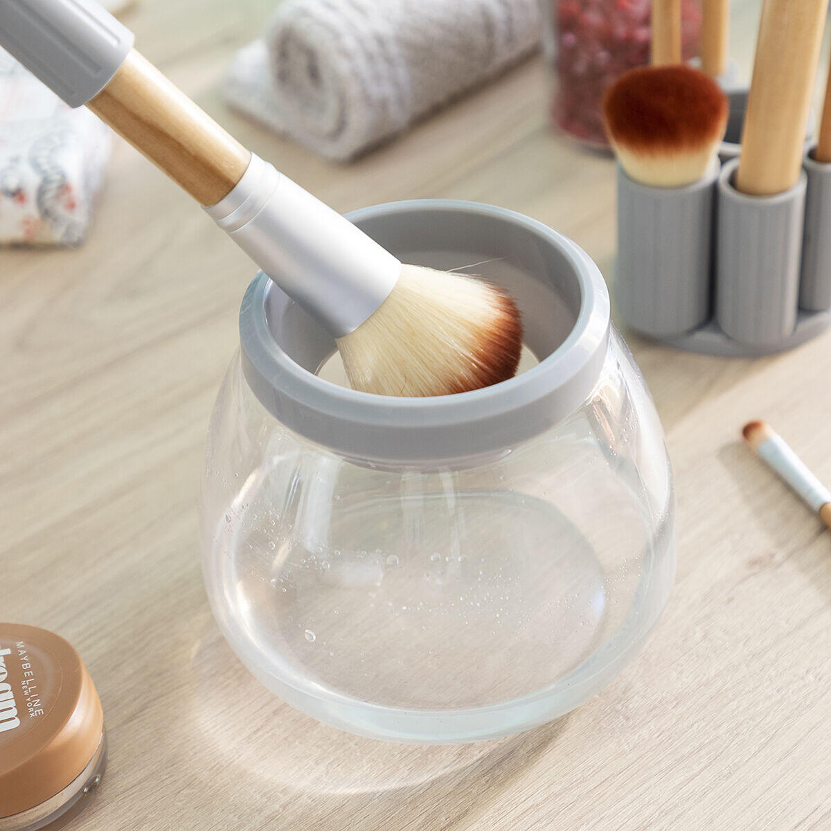 Limpiador y Secador Automático de Brochas de Maquillaje Maklin InnovaGoods con una brocha escurriendo 