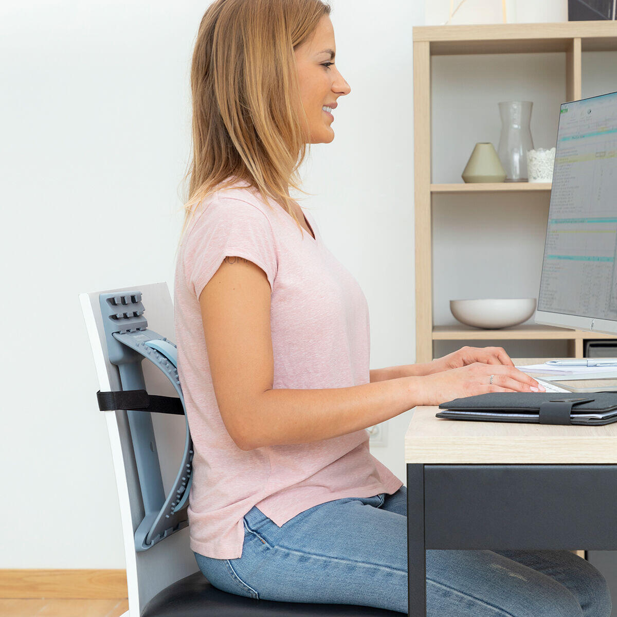 mujer sentada recostado sobre el soporte corrector de estiramiento lumbar con puntos de presión y magnéticos Lumport 
